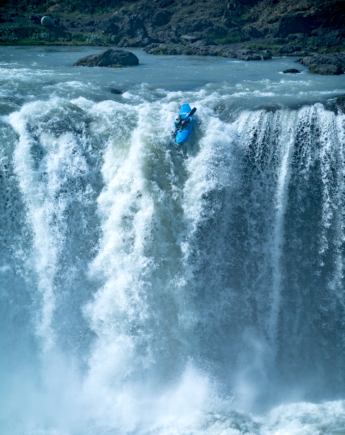 Kayaker reaches the edge of a big waterfall. No turning back